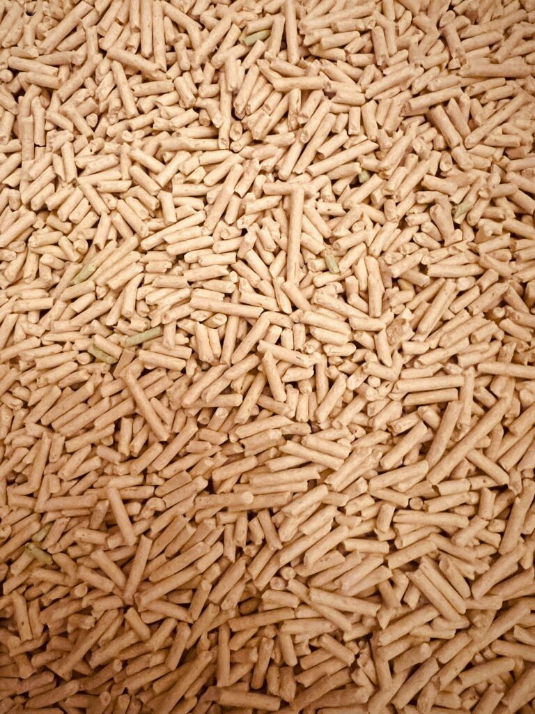 A detailed top view of a large pile of wood pellets used for renewable fuel and energy.