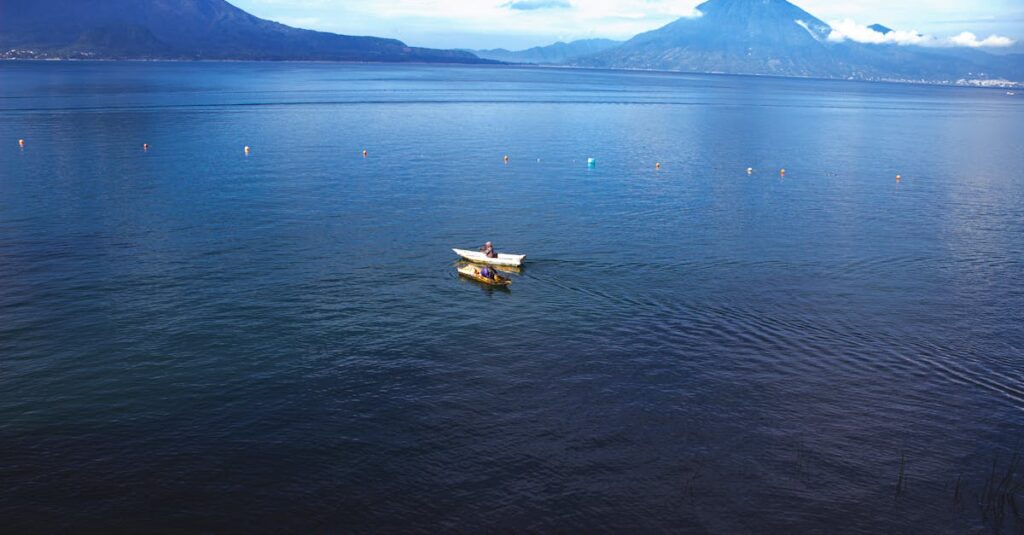 A tranquil scene of a boat on Lake Atitlán, Guatemala with mountains in the background.